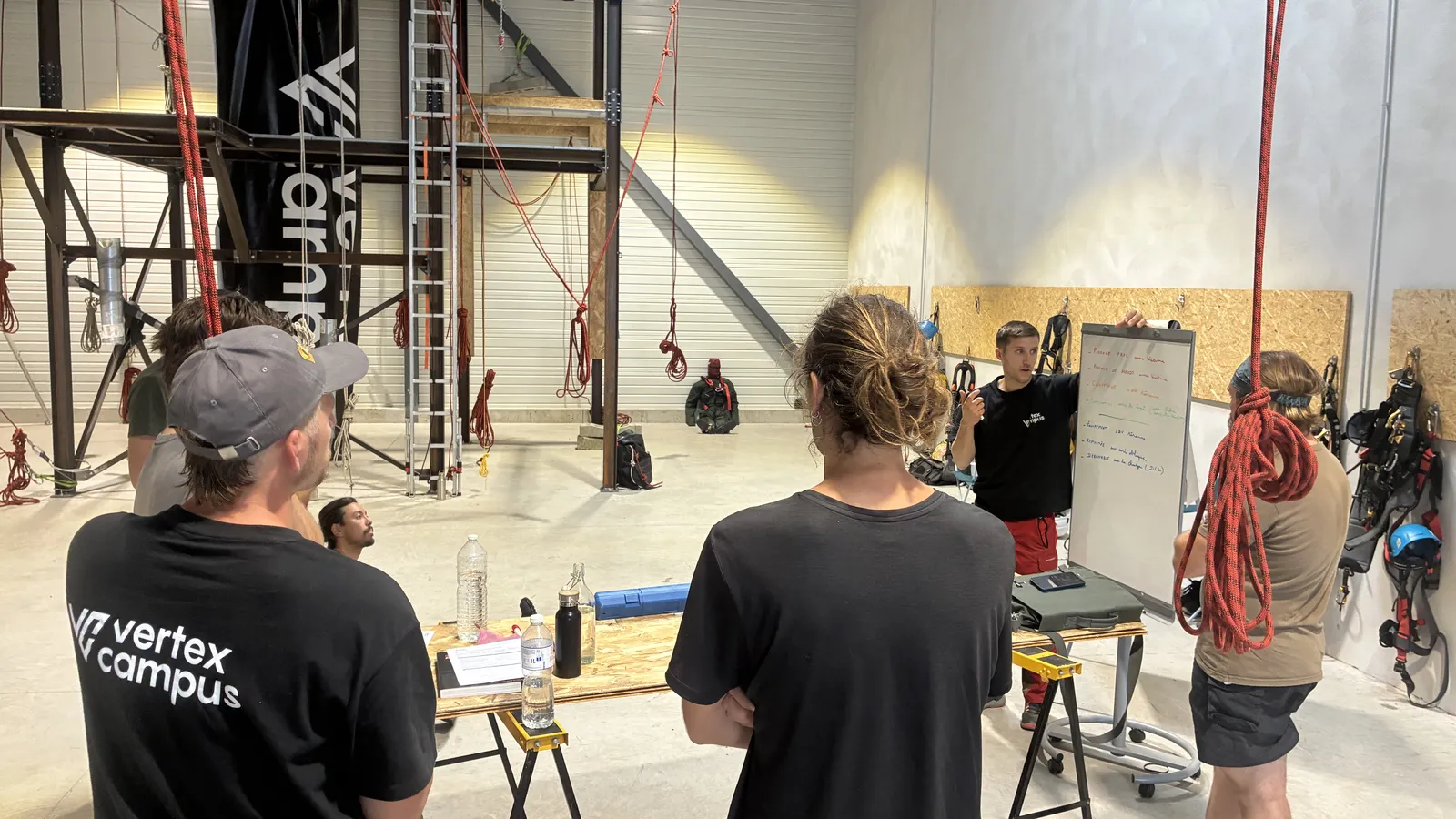 Formateur en t-shirt Vertex Campus face à des stagiaires dans la halle