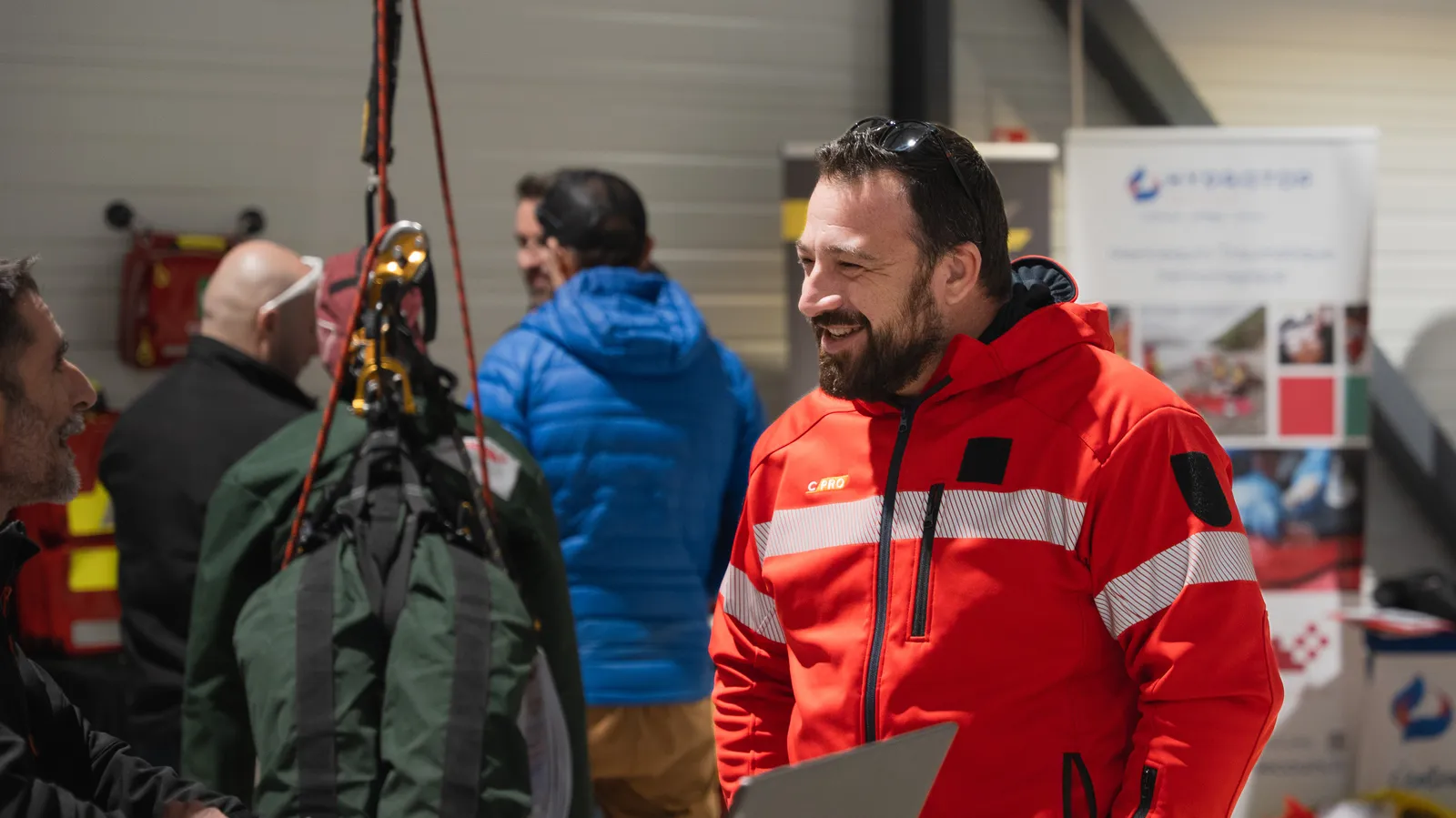 Échanges entre un formateur et un visiteur devant les stands du salon